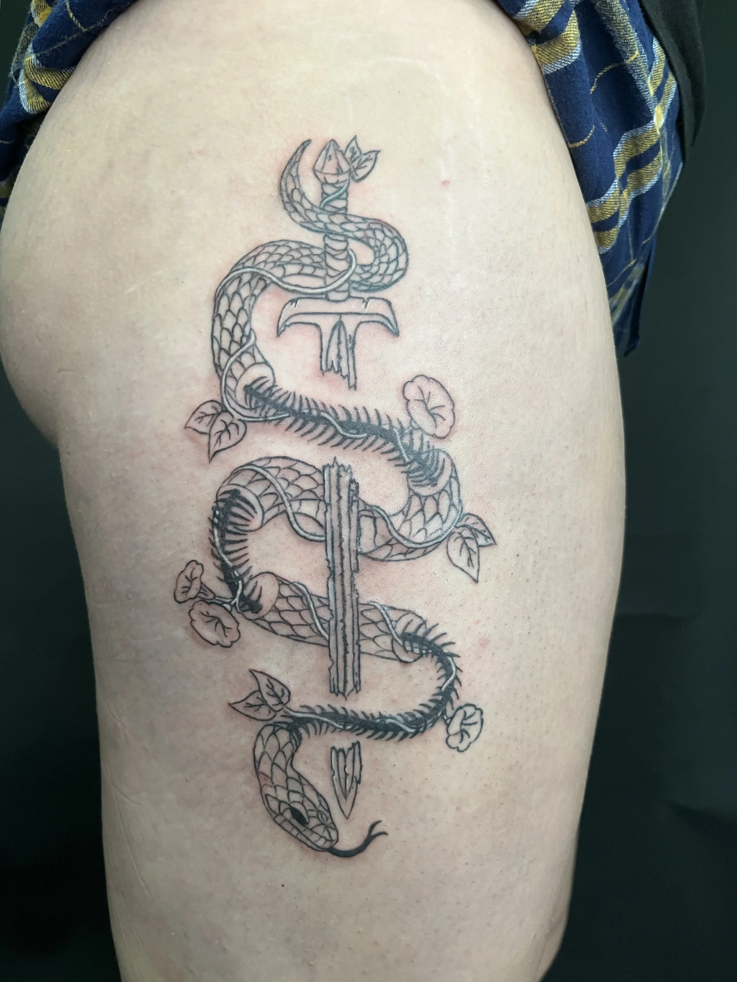 Tattoo of a snake wrapped around a sword.
