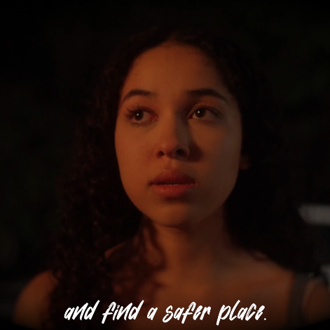 Close-up of a young woman with curly hair looking thoughtfully into the distance at night.