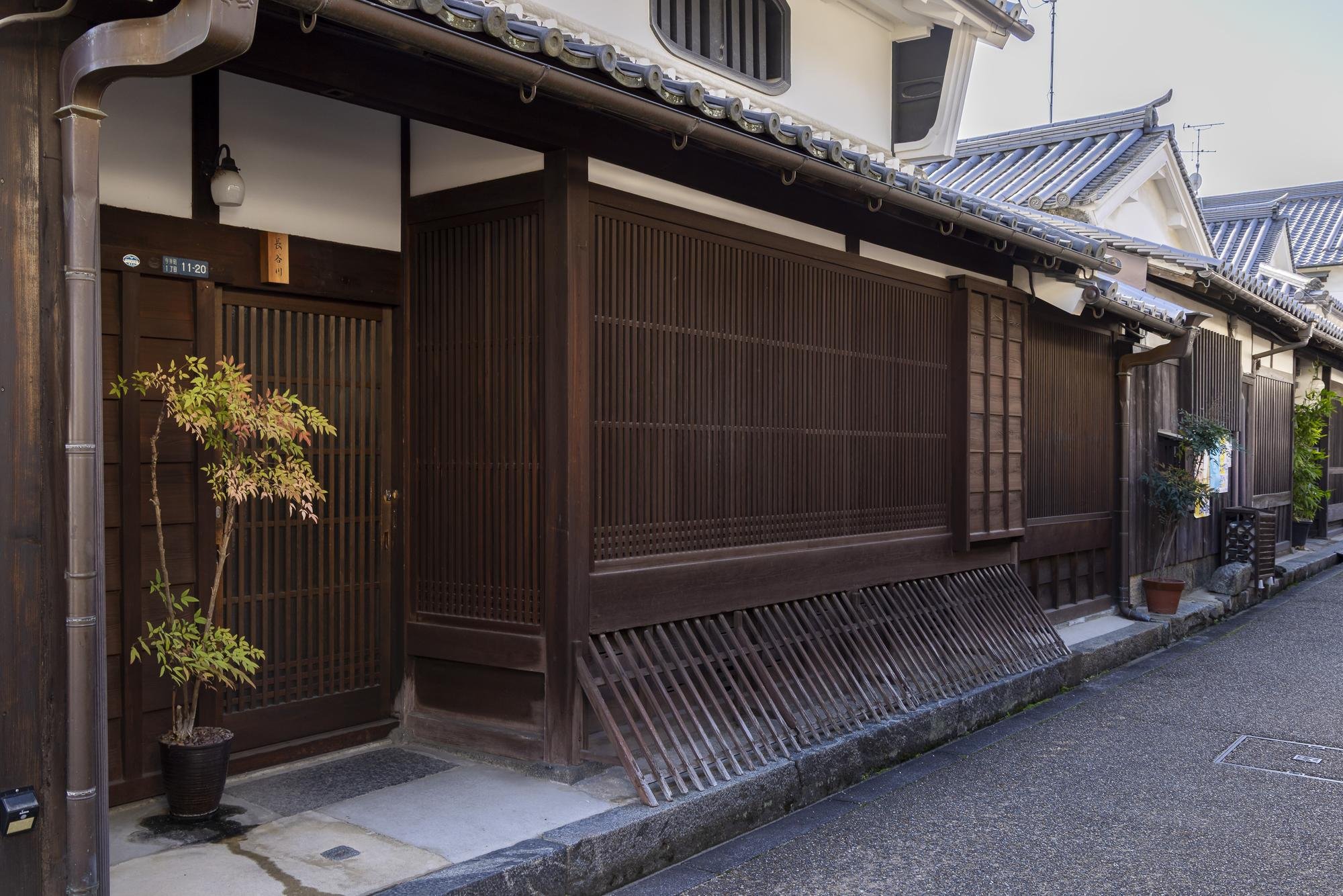 A narrow street lined with traditional Japanese wooden houses with tiled roofs.