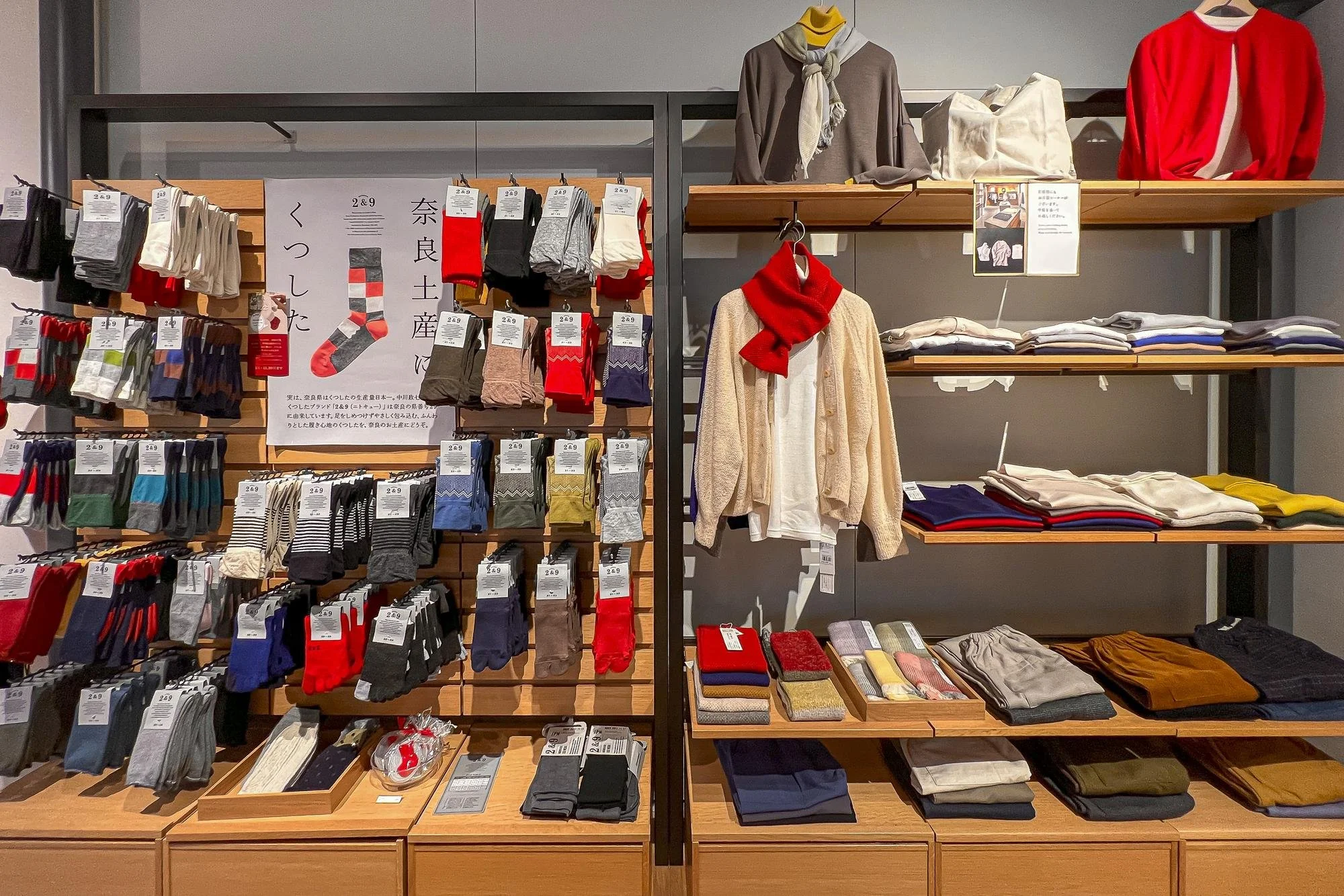 Display of socks, sweaters, and clothing items on shelves in a store.