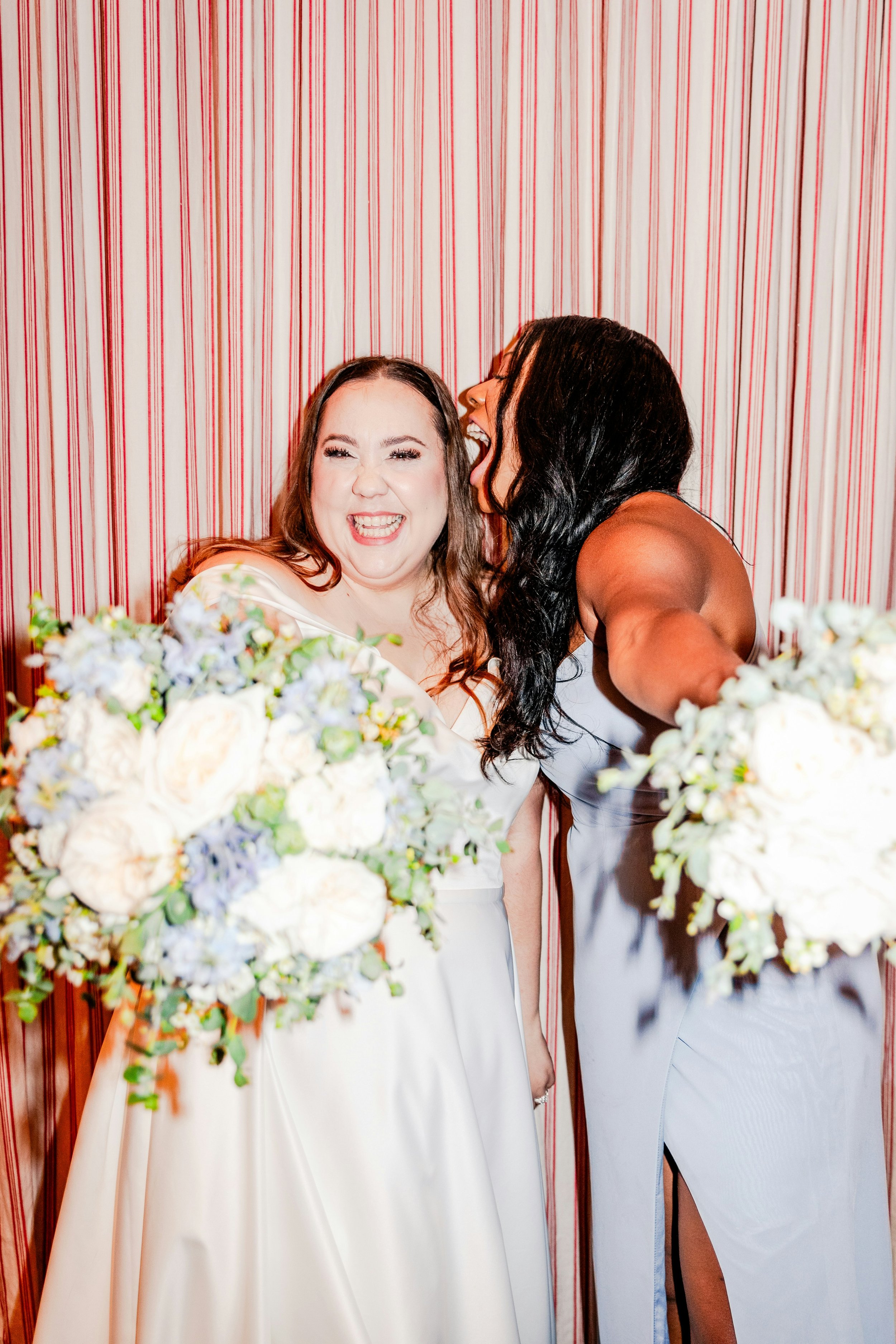 bride and bridesmaid hold bouquets to the camera