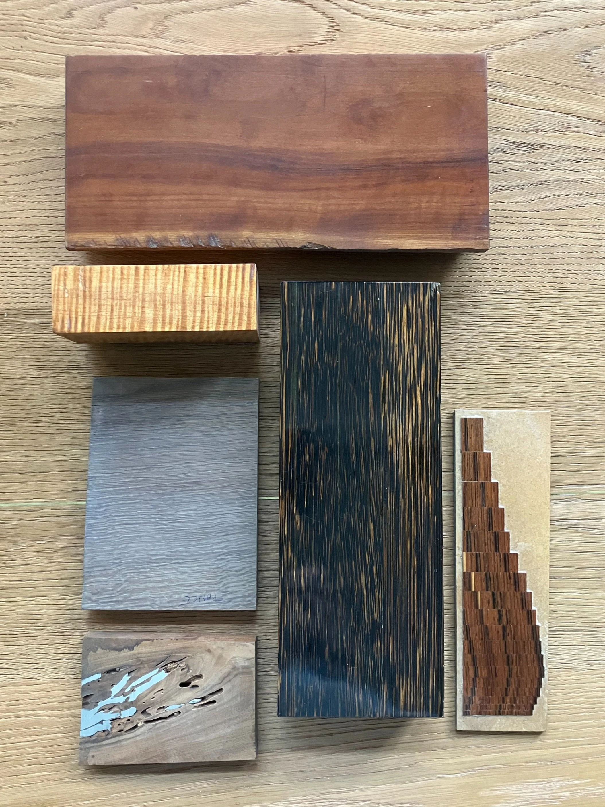 Dix échantillons de différentes textures et couleurs de bois, disposés sur une surface en bois clair.