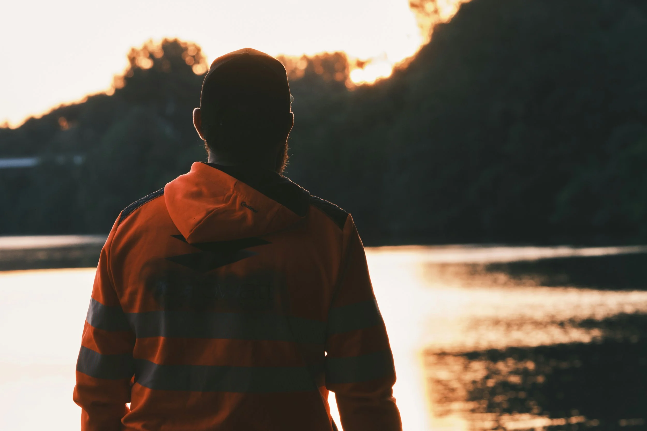 Why we need relationships: a person reflecting by a lake at sunrise, symbolising human connection and emotional reflection