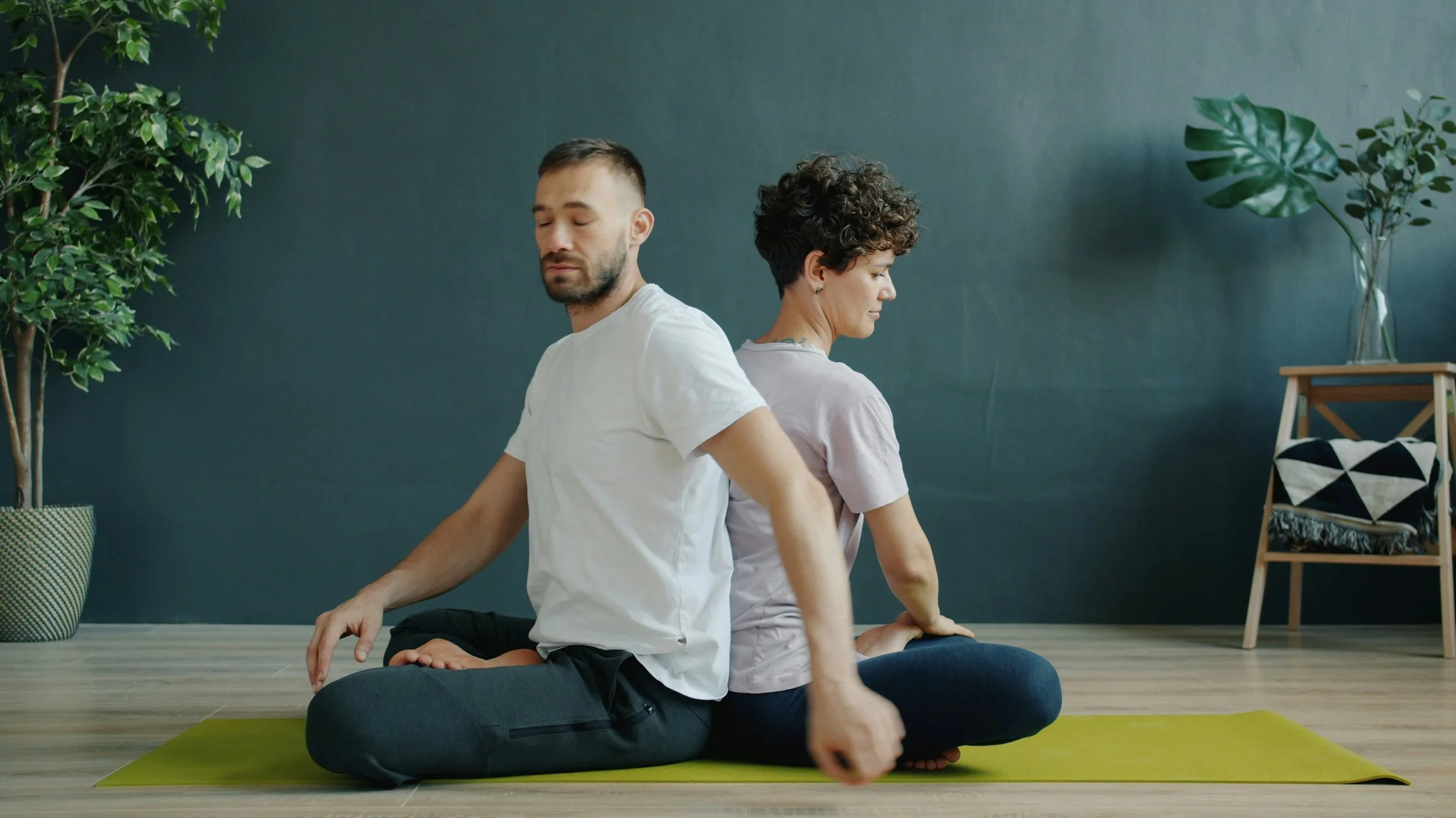 Two people meditating back to back, symbolising mindful dating, emotional balance, and slowing down in relationships
