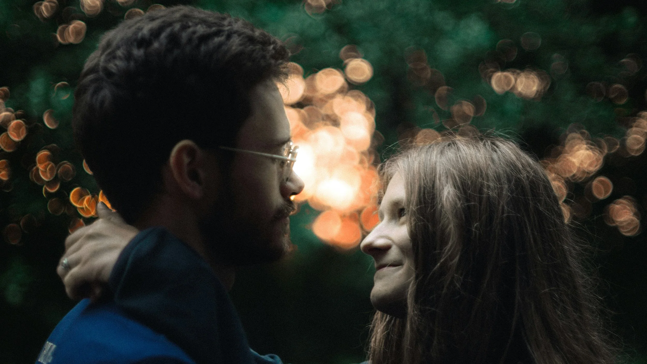 Couple embracing with soft lights, representing real-world attraction beyond dating apps and the limits of digital connection