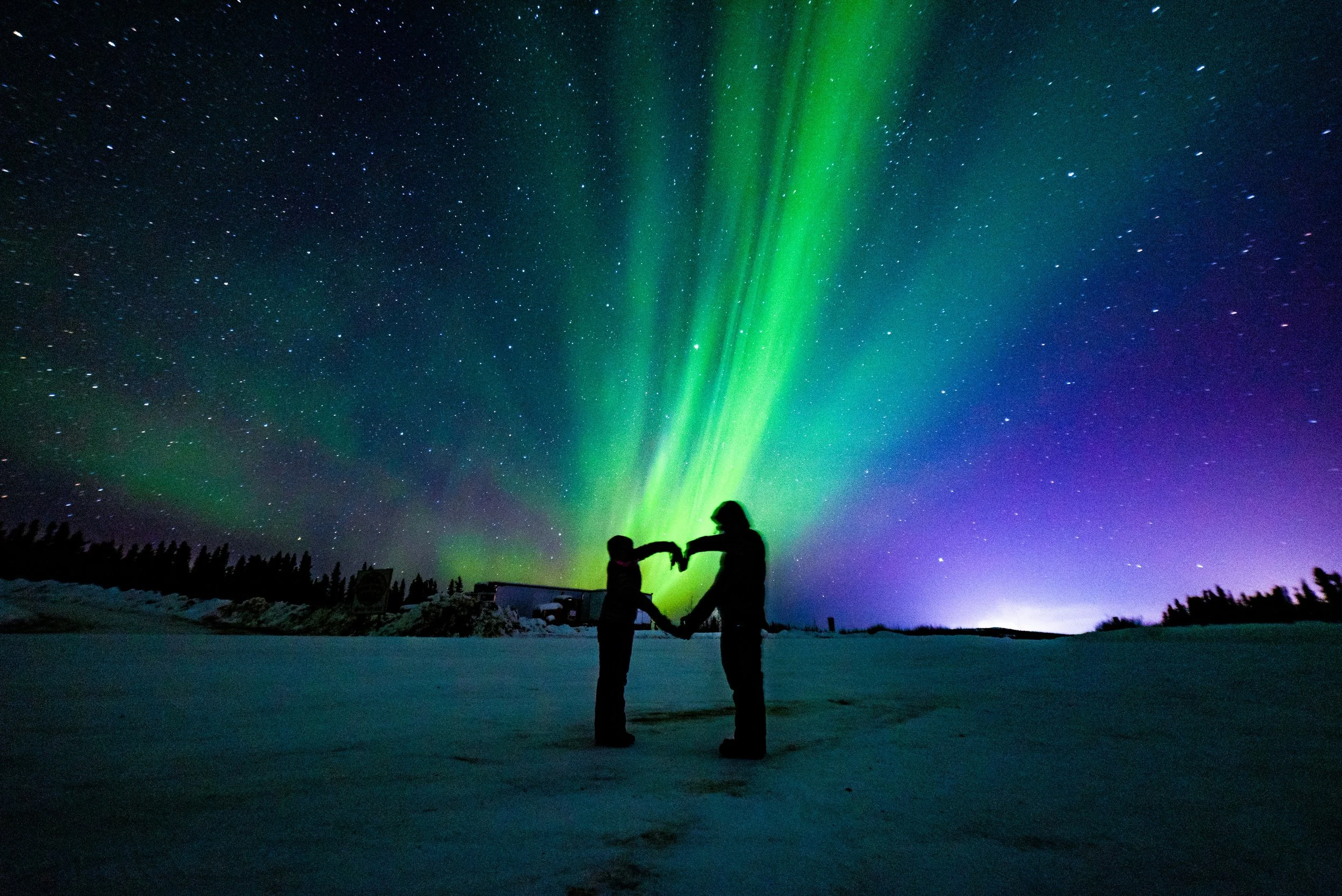 Friends holding hands under starry sky representing Valentine’s Day traditions in Finland and Ystävänpäivä friendship celebrations