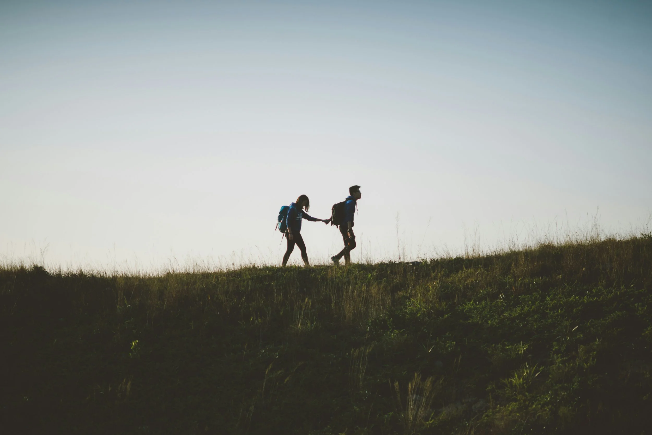 Couple walking outdoors hand in hand representing low-pressure Valentine’s Day ideas for couples in nature