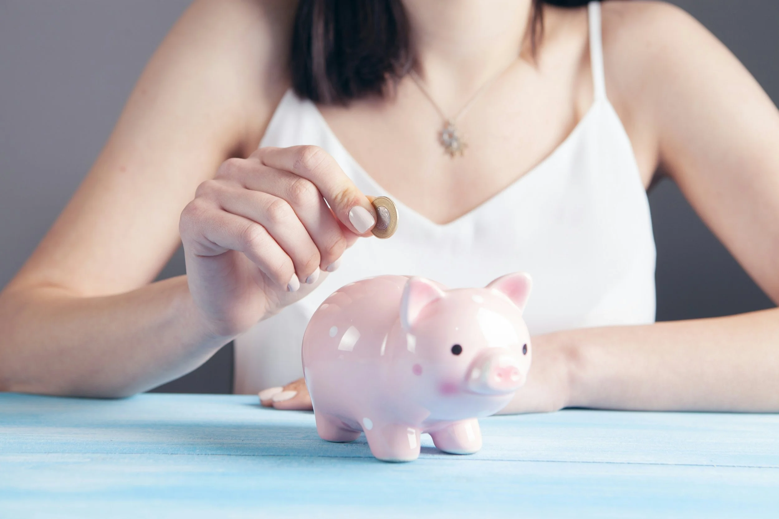 Woman holding a piggy bank symbolising budget concerns and financial pressure around Valentine’s Day for couples