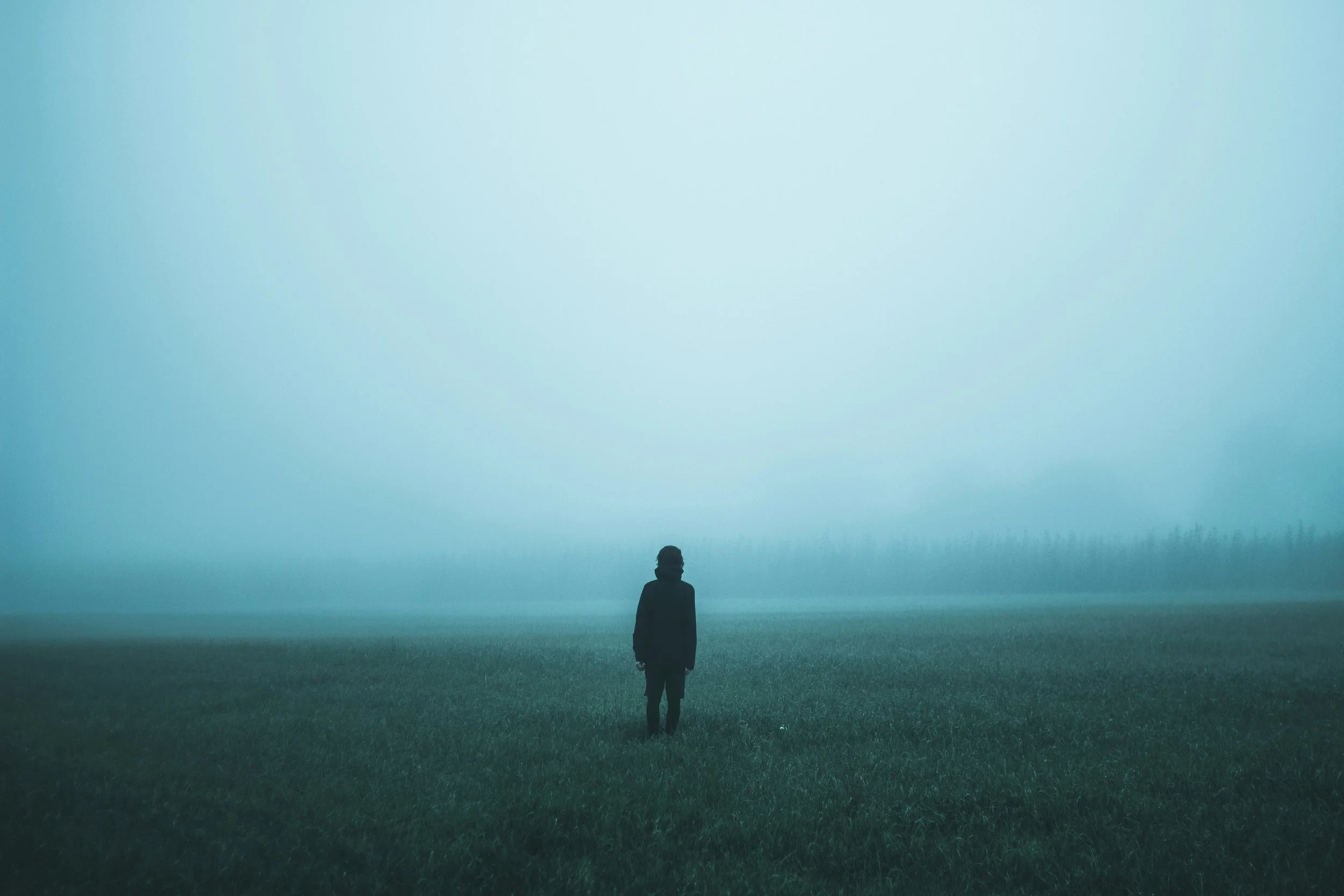 Person standing alone in misty landscape, reflecting emotional uncertainty in modern dating