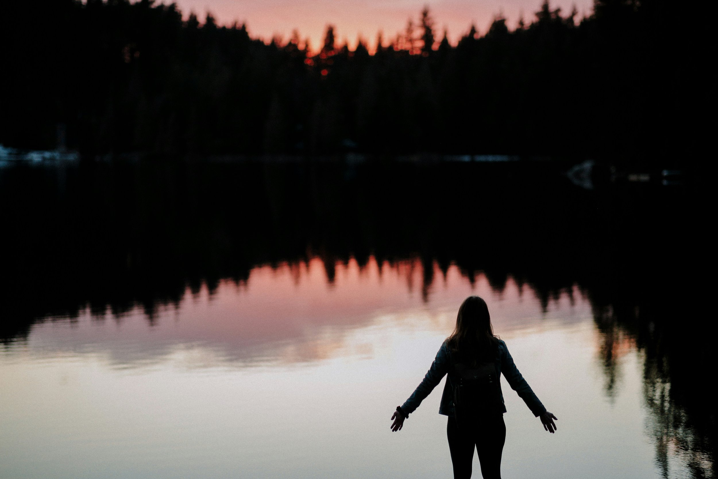 Silhouette of a person by water at dusk, representing mental health and emotional wellbeing on Valentine’s Day