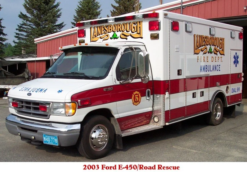 2003 Ford E-450 road rescue ambulance for the Janesborough Fire Department with red and white color scheme, emergency lights, and medical equipment storage compartments.