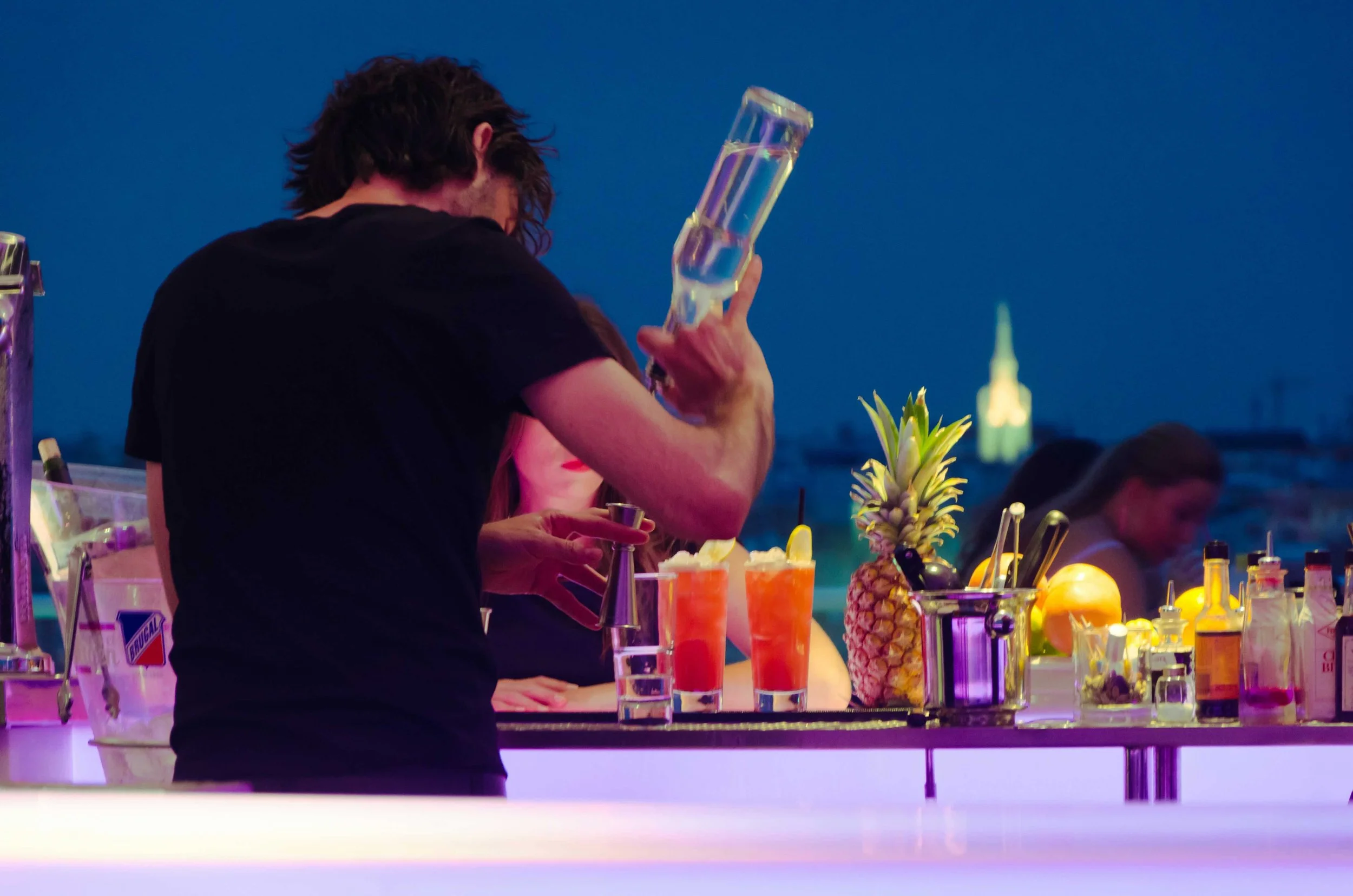 Barkeeper der am Abend bei After Work Party Cocktails mixt