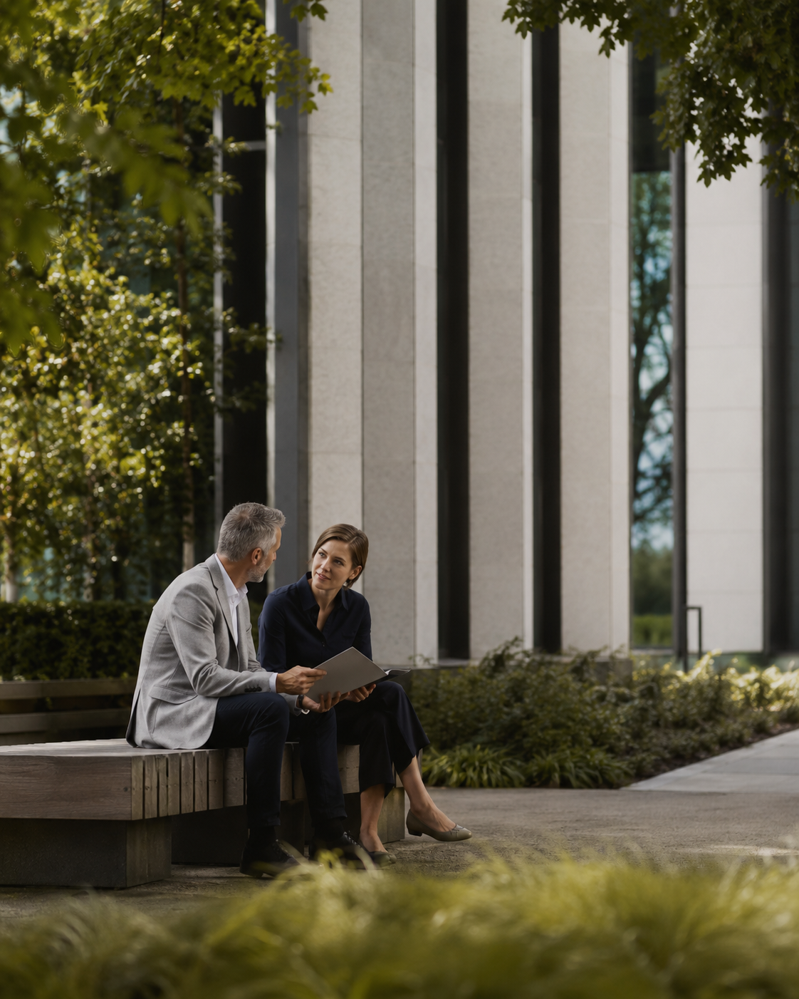 Adviser and client sitting on a bench outside an office, calmly discussing retirement income options