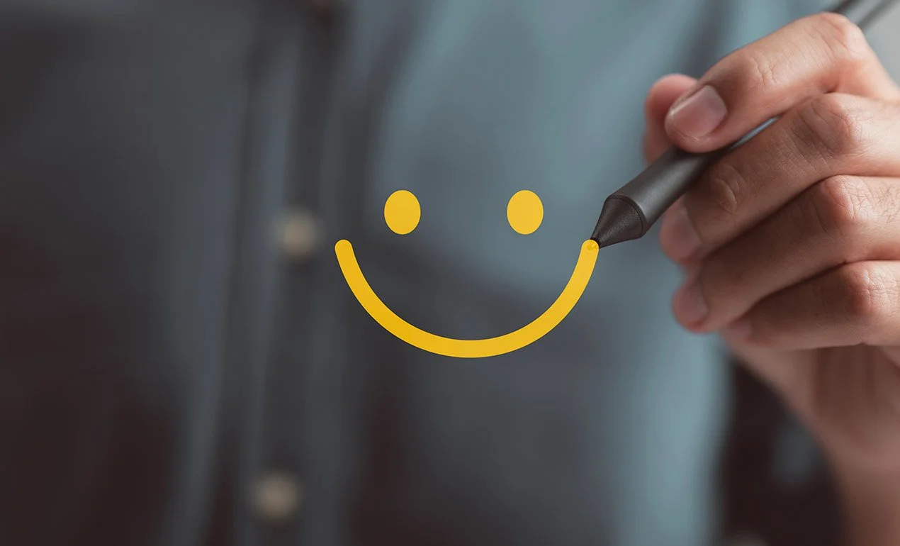 smiley-face being drawn on glass wall with bright yellow marker
