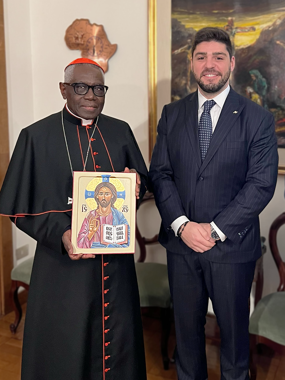 Alessandro DiSanto (co-founder of Hallow) gifting Cardinal Robert Sarah one of Kai's icons