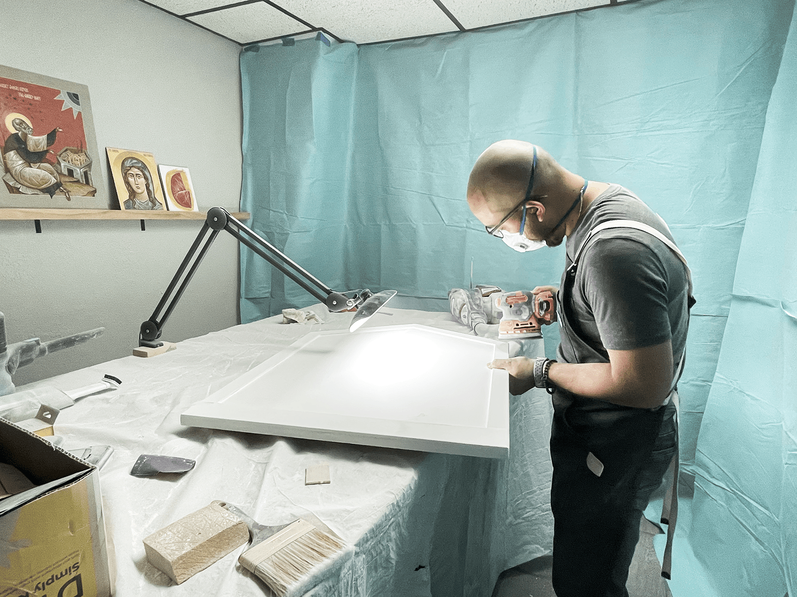 Sanding gessoed panels.