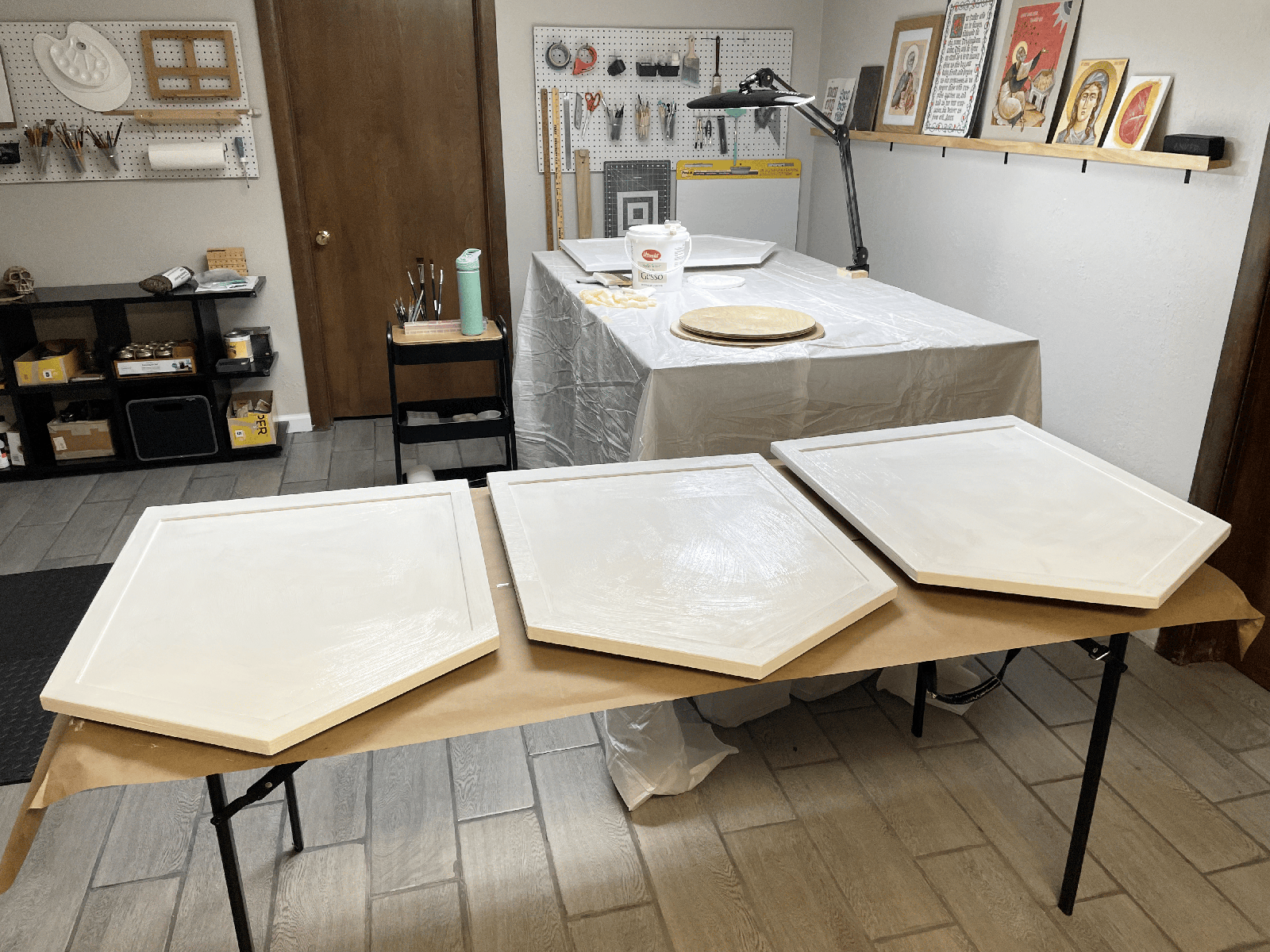 Applying several coats of gesso to the wooden boards