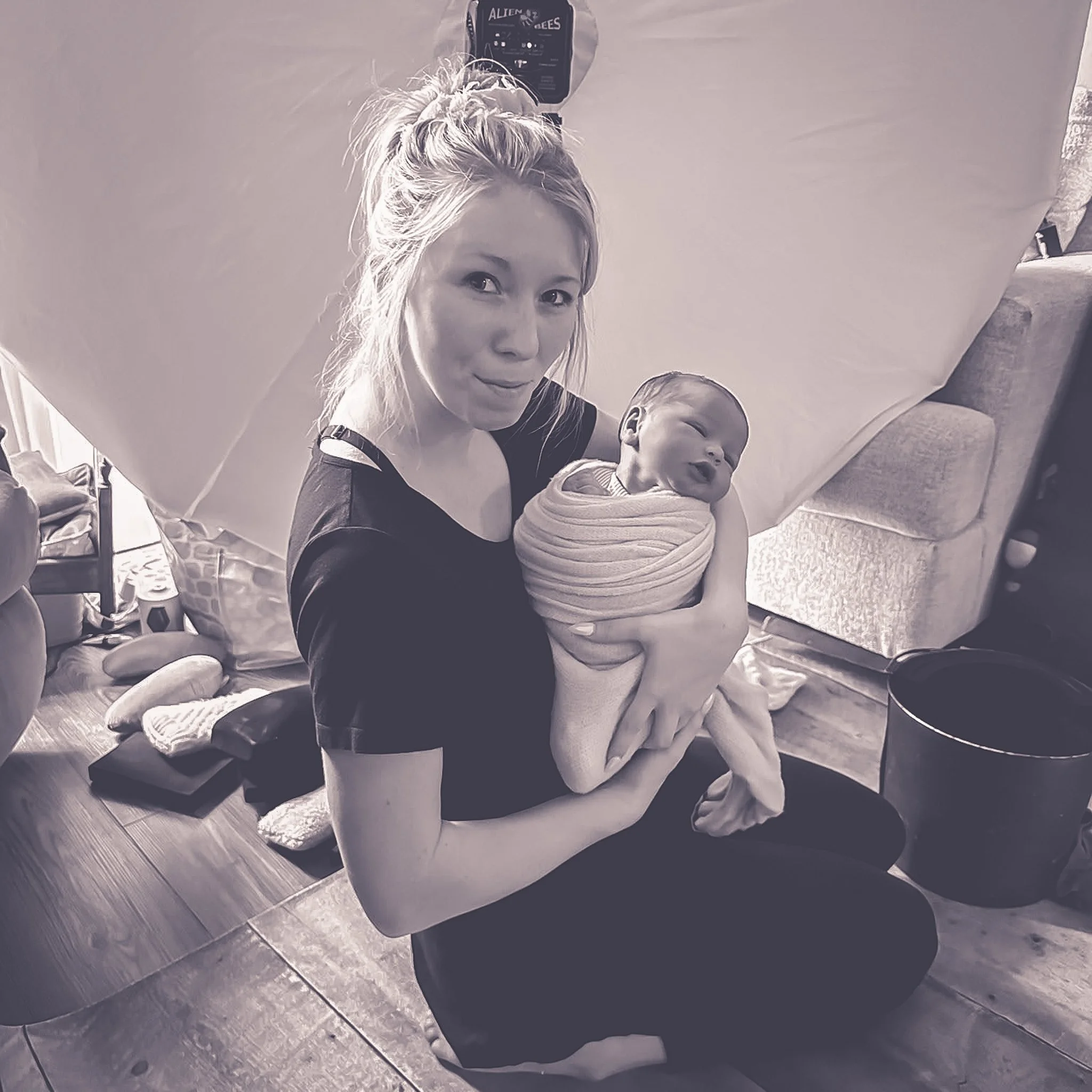 Woman photographer holding a newborn baby.