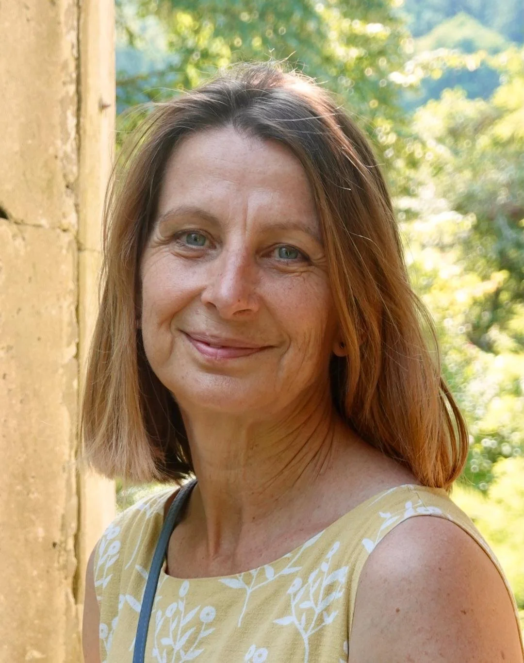 head and shoulders of woman with trees in the background