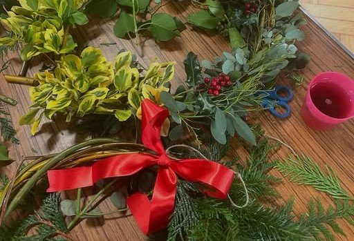 picture of evergreen twigs, red bow and other materials for wreath making