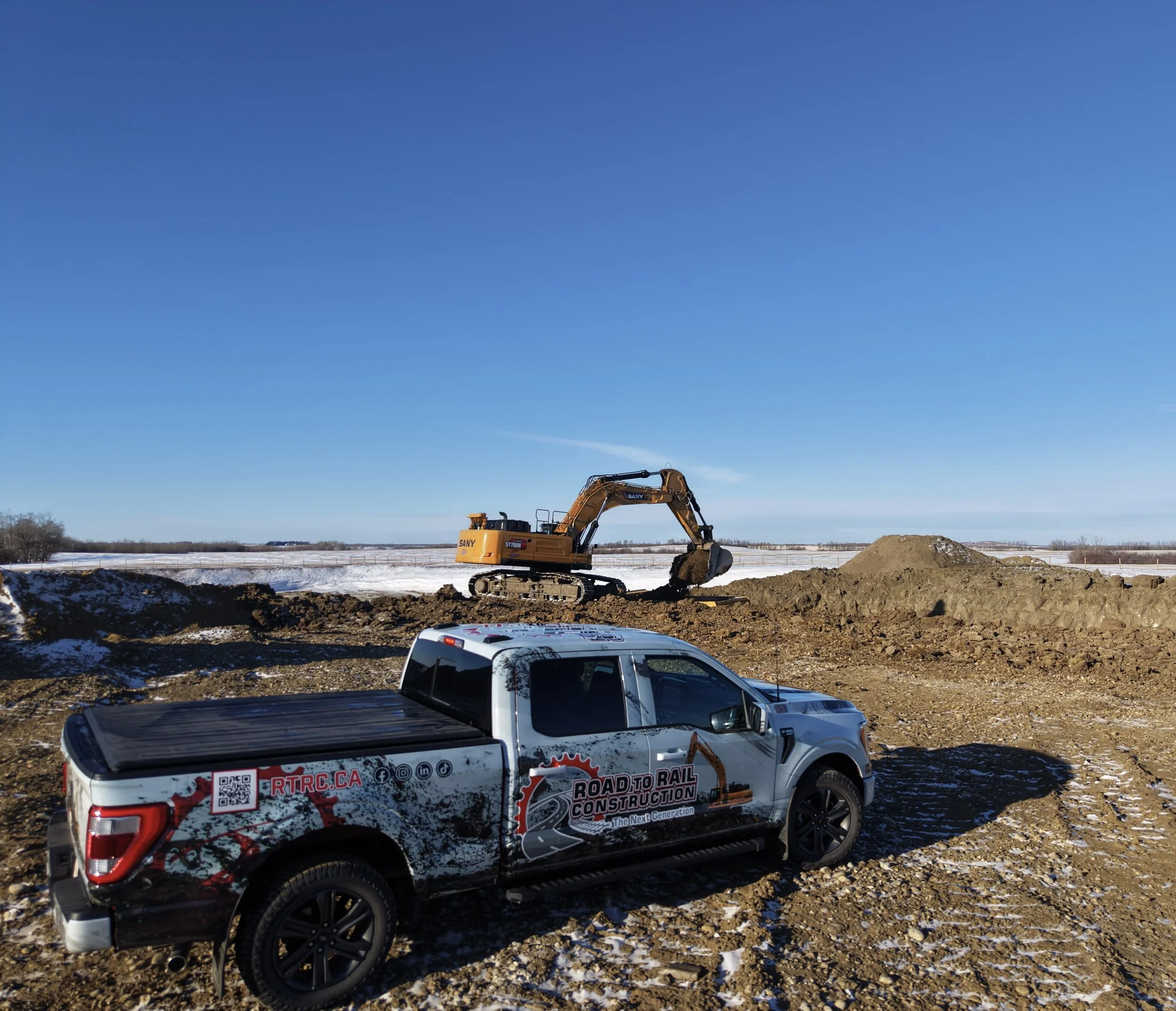A trailer with the words "Site Solution Services" and a logo, parked at a construction site with workers and heavy machinery in the background.
