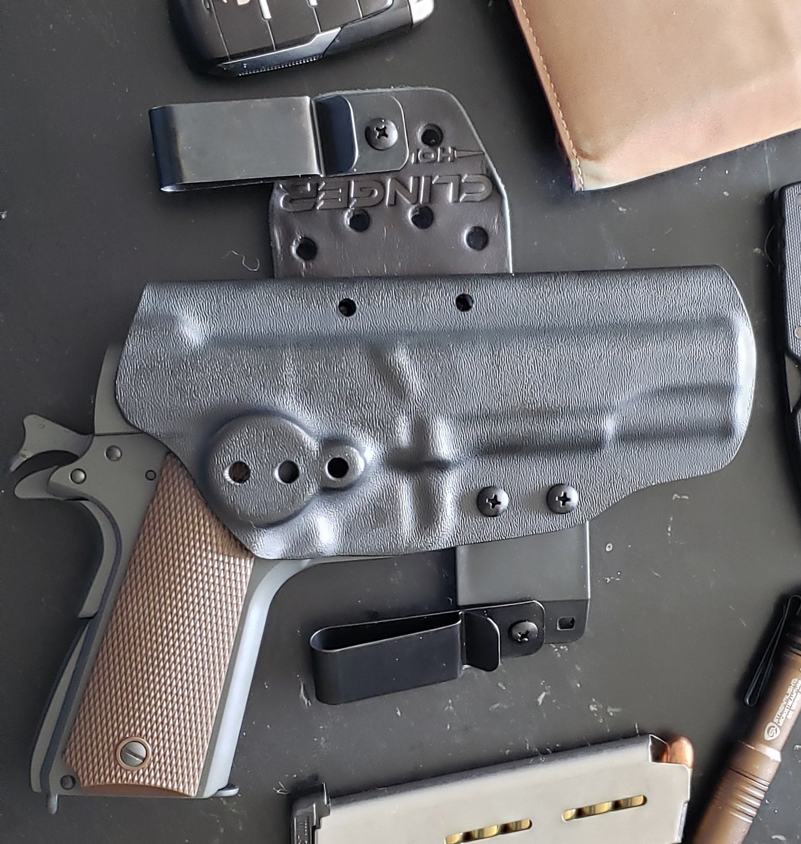 EDC gear laid out and Clinger Holster IWB Hinge holstering a cocked and locked Tisas 1911A1