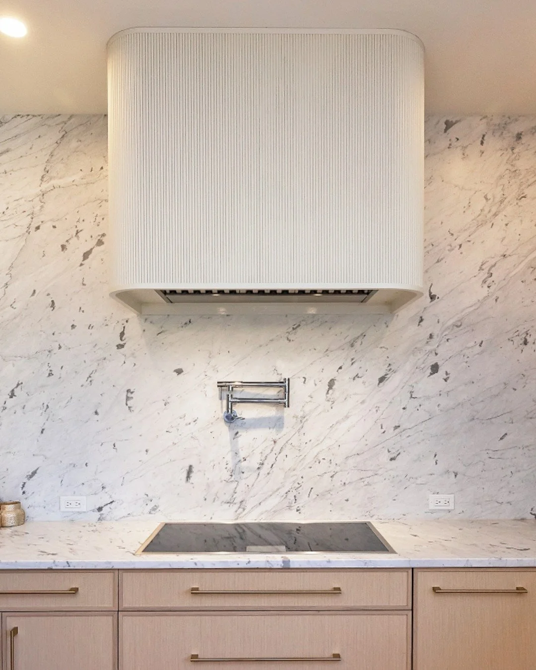 Sleek lines, natural stone, and custom details, this kitchen was designed with both beauty and function in mind. From the striking marble backsplash to the built-in pot filler and custom hood, it&rsquo;s the perfect balance of style and practicality.