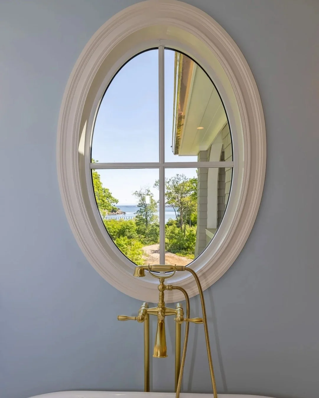 A view like this doesn't need much else. The soft curves of the window, paired with warm brass fixtures, create a moment that feels both classic and elevated. Simple, intentional, and designed to let the surroundings speak for themselves.

#BathroomD