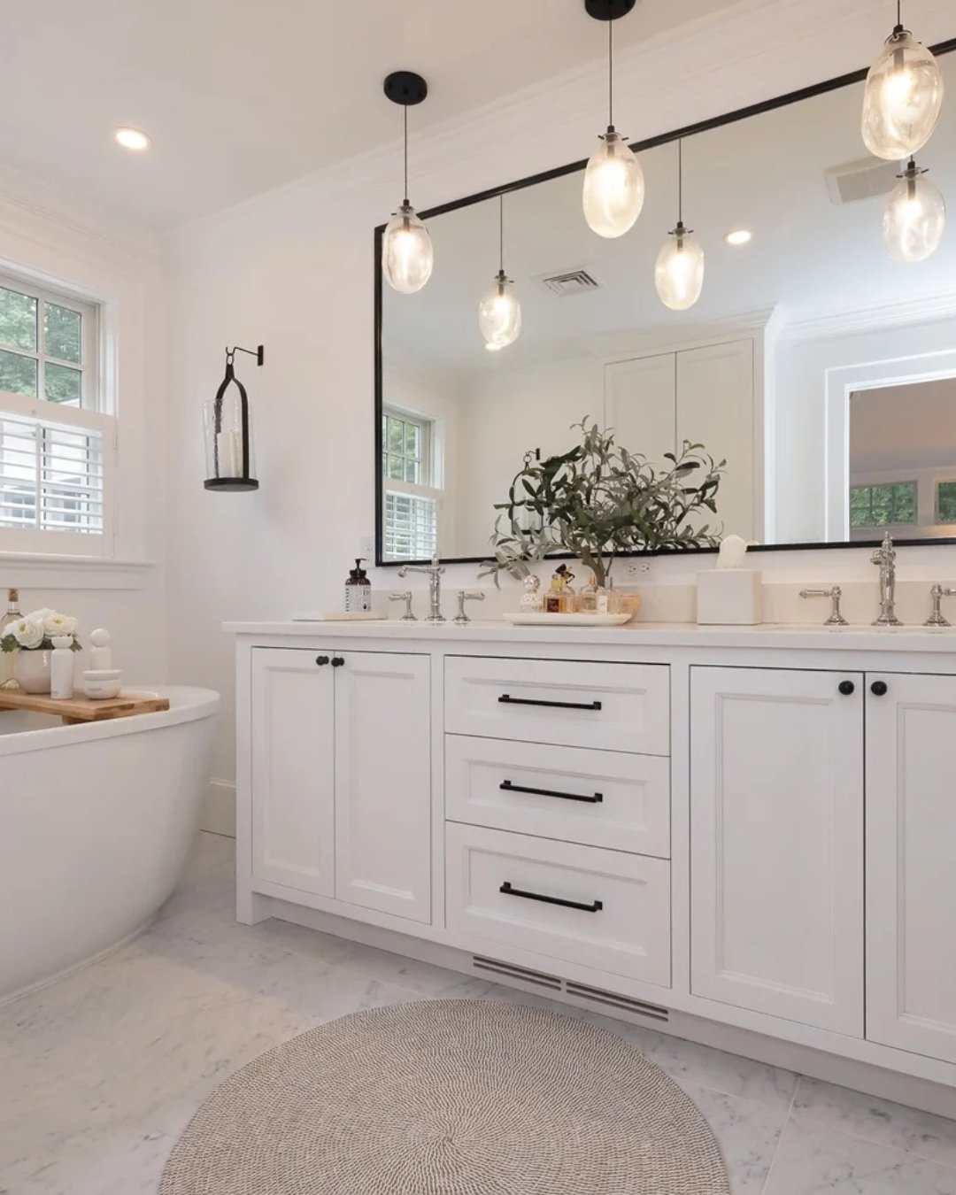 A bathroom designed to feel calm from the moment you from the moment you enter.

Bright white finishes, contrasting black hardware, a full-width mirror, and a double vanity create a space that is both functional and quietly refined&mdash;anchored by 