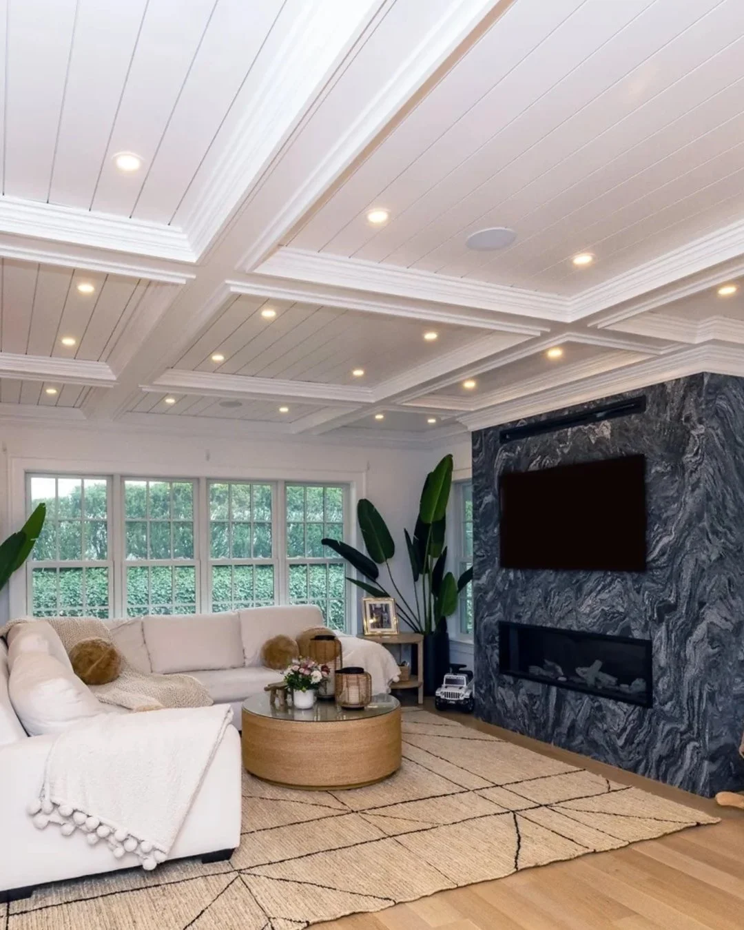 A living space that does it all. The coffered ceiling adds depth and detail, while a bold stone fireplace anchors the room. Soft textures, natural tones, and oversized windows keep it feeling light, open, and effortlessly comfortable. Designed for ev