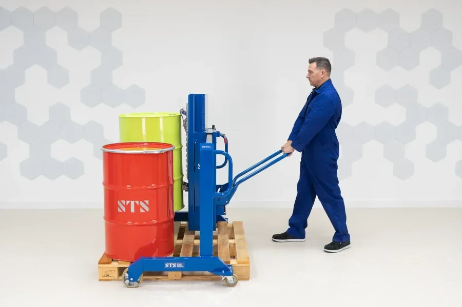 Operator lifting drum with equipment that straddles the pallet