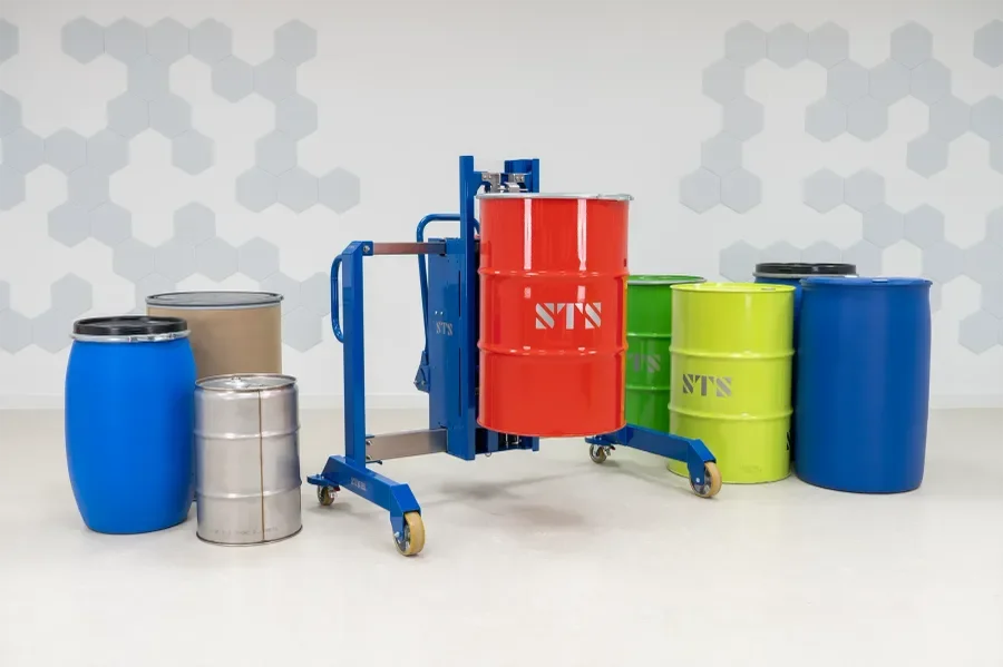 A collection of varying sizes and types of drums pictured with an electric drum lifter holding a 55 gallon steel drum