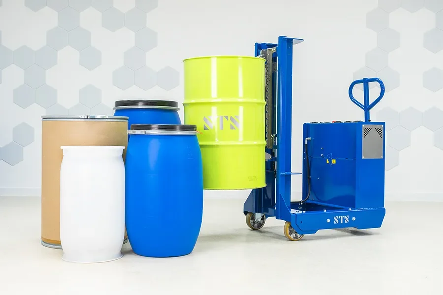 Operator is steering the electric lift counterbalance drum lifter while it's holding a steel drum