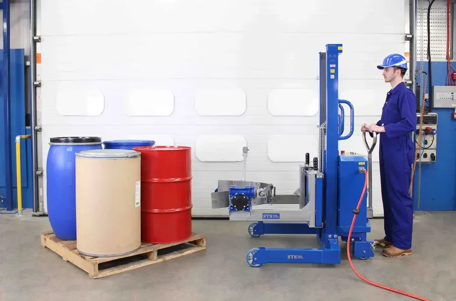 operator is using a pneumatic drum lifter and pourer to pick up a 55 gallon drum