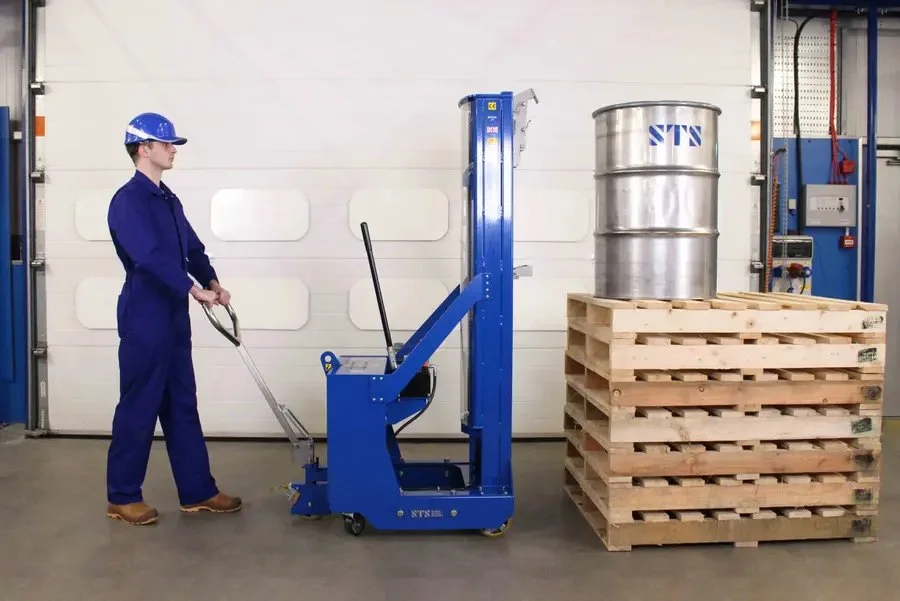 persn using a tall drum lifter to pick up a drum from a tall stack of pallets