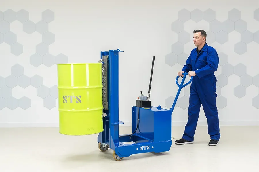 Operator is steering the manual counterbalance drum lifter while it's holding a drum