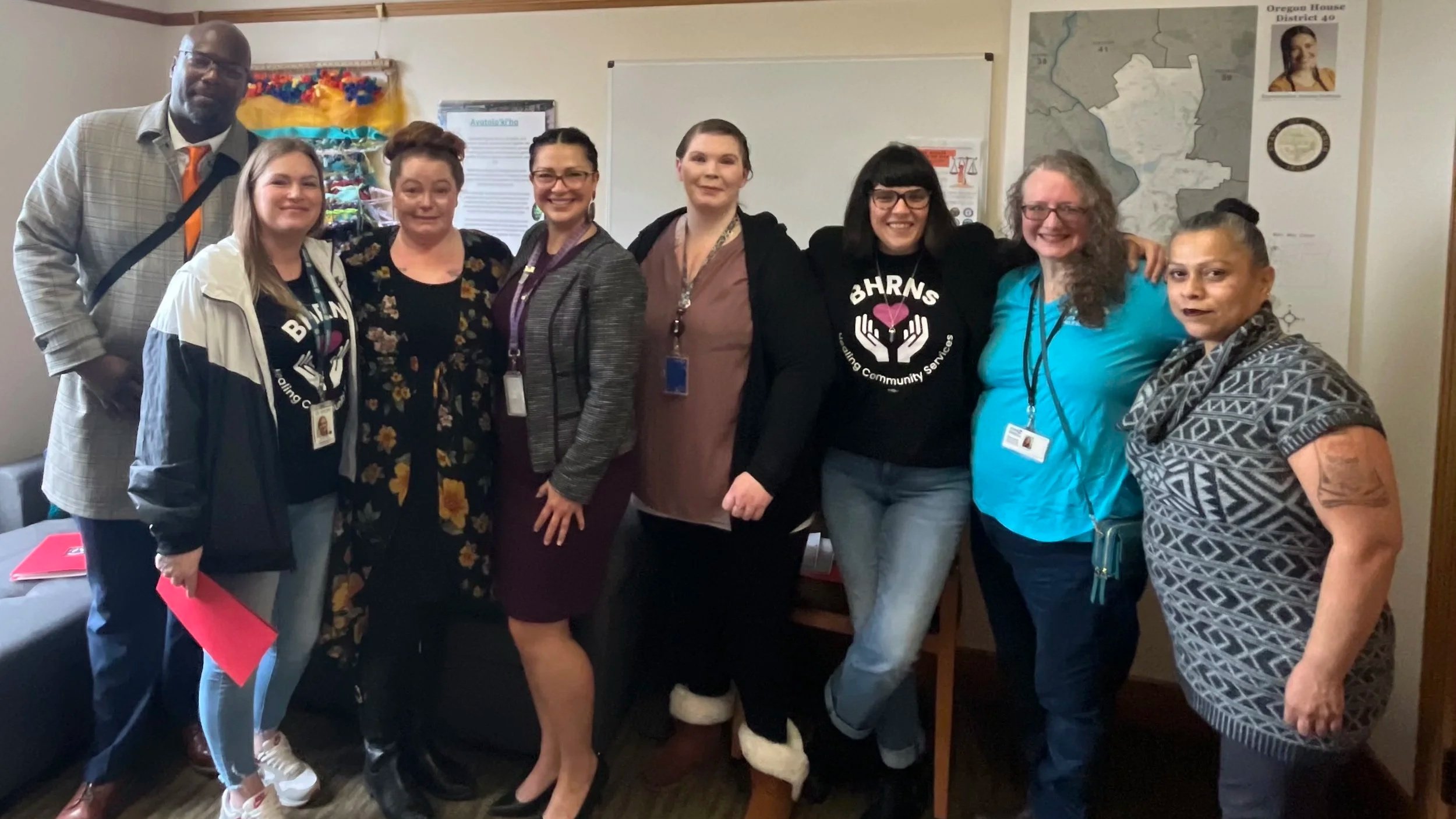 Group of nine HJRA advocates smile with their arms around one another.