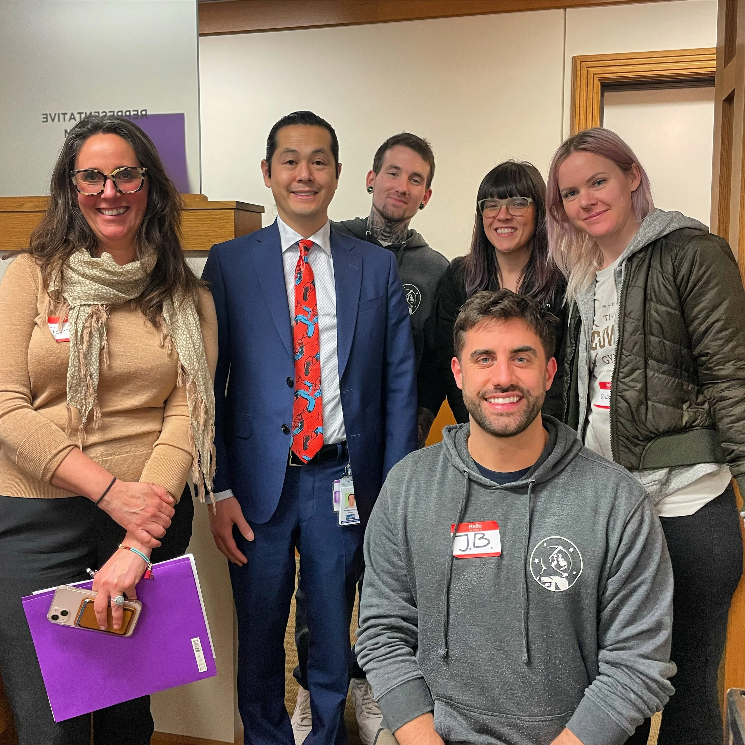 Group of 6 HJRA advocates and staff, including former Executive Directors Tera Hurt and Devon Downeysmith, stand indoors, smiling at the camera. 