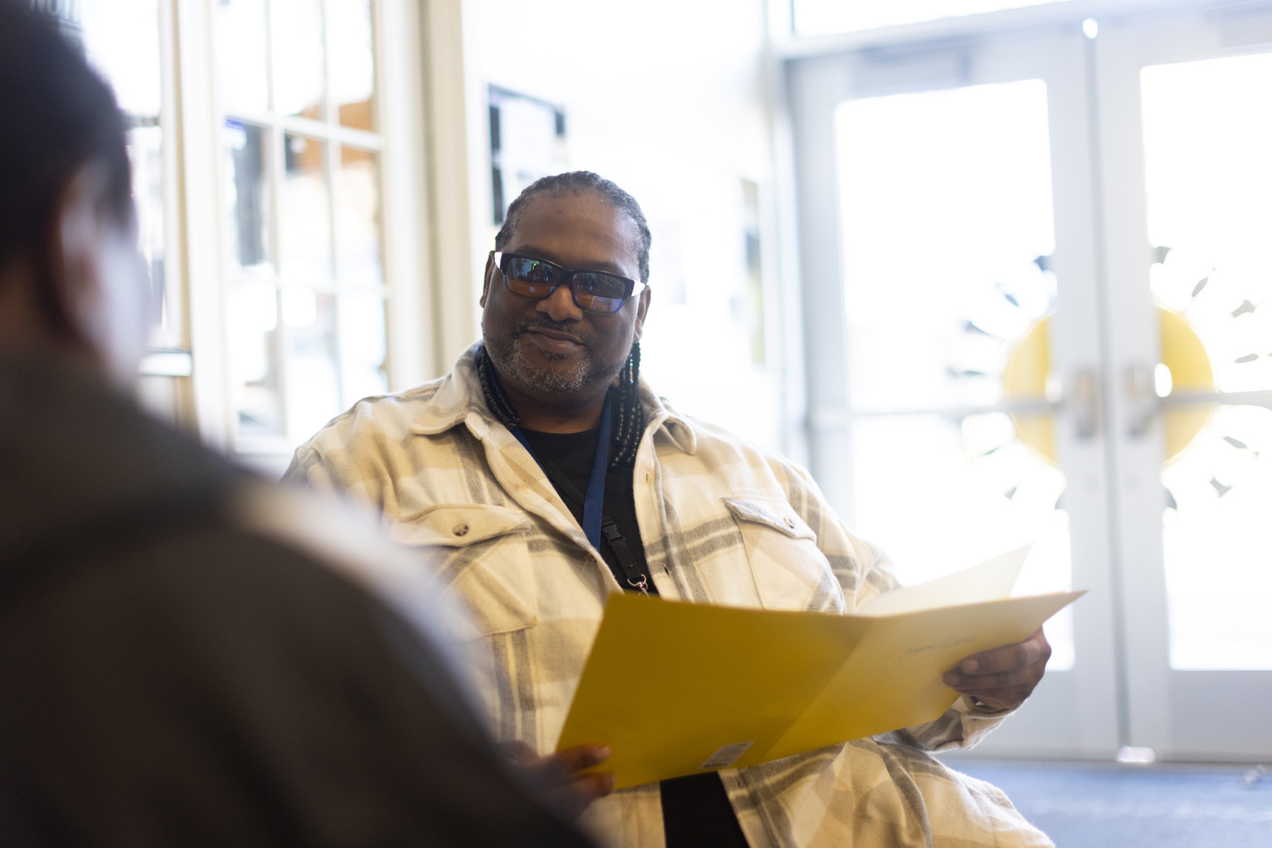 A provider smiles facing another person whose back is to the camera. Fresh Out and Miracles Club demonstrate the power of peer recovery mentorship through their Measure 110 programming and beyond.
