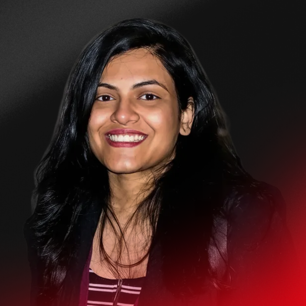 Blurry portrait of a person with short dark hair wearing a black top against a light background.