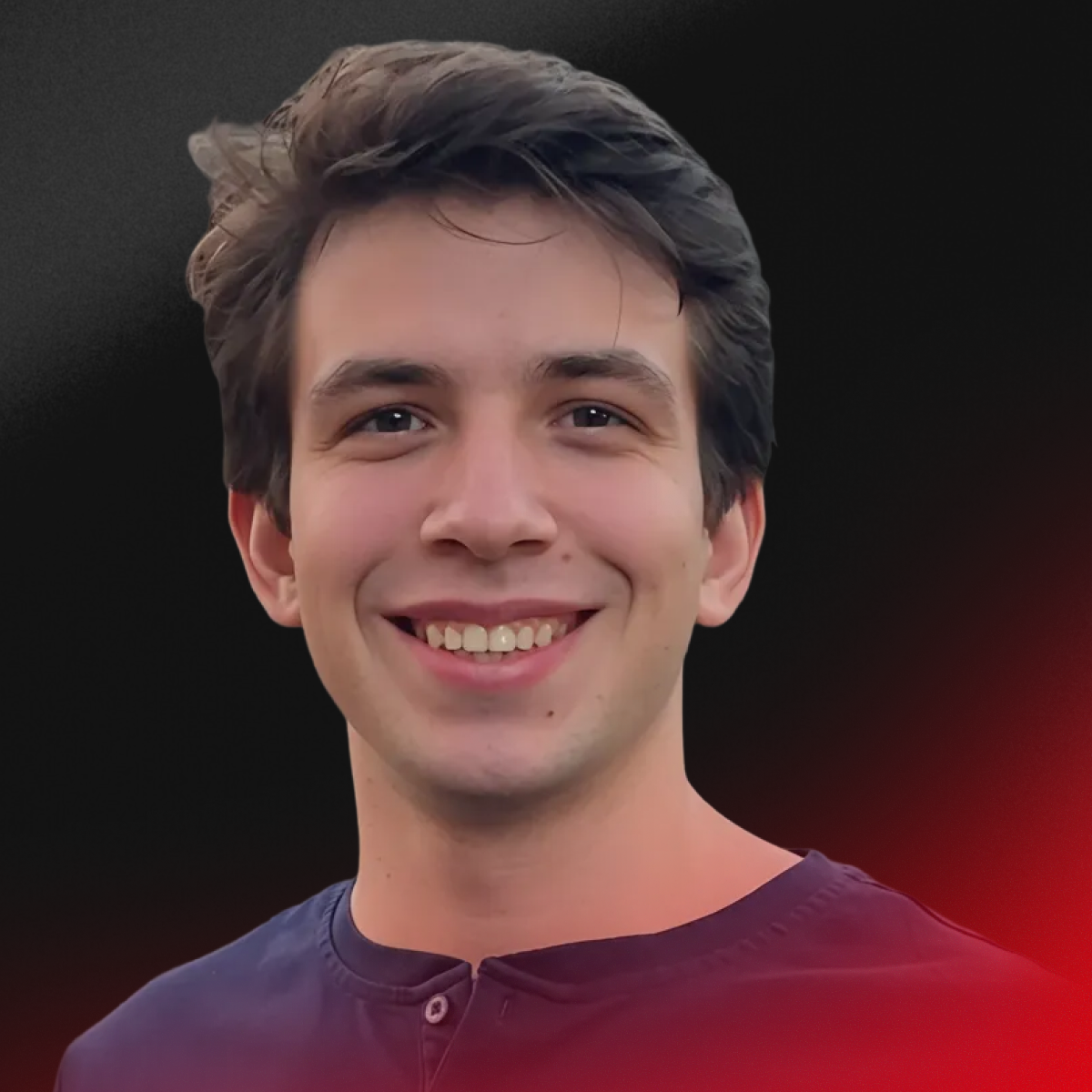 A young man with brown hair smiling at the camera, dark background, wearing a dark shirt.