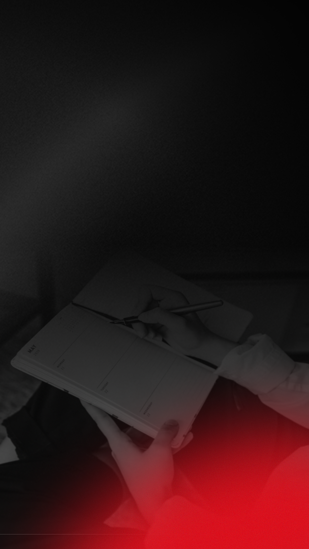 A person wearing white gloves is writing in a planner or journal.