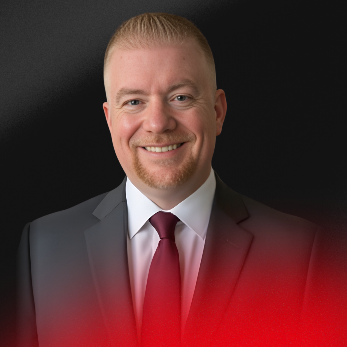 Blurred image of a person with short dark hair, wearing a black top, against a light background.