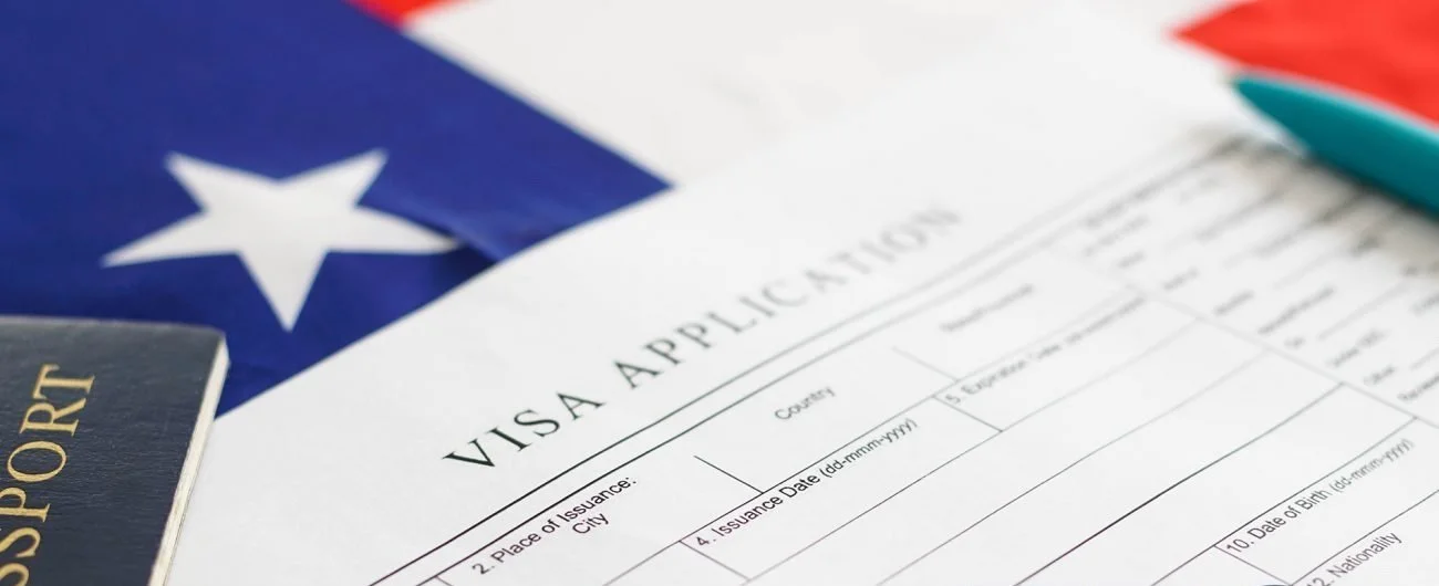 A visa application form, a passport, and a flag with a white star on a blue background.