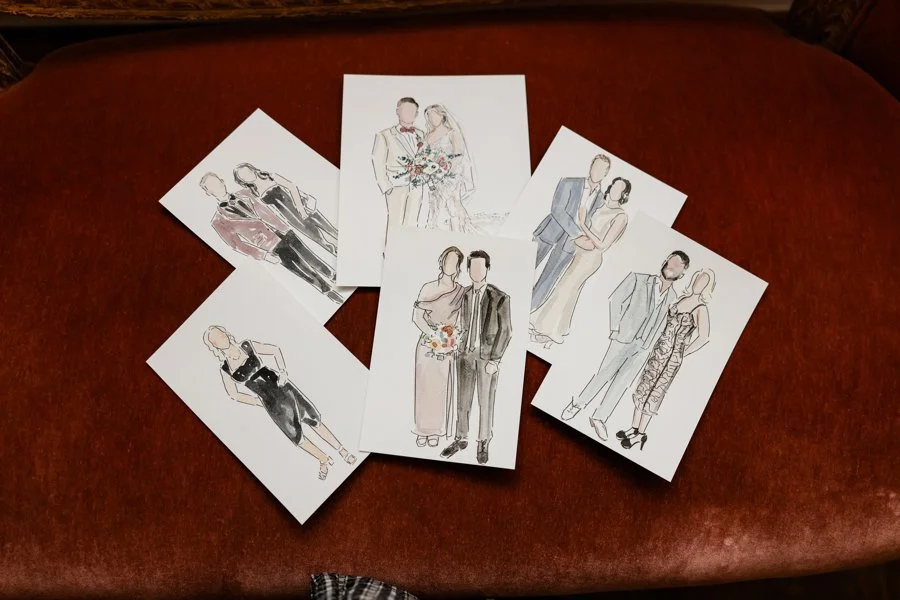 Collection of hand-drawn wedding illustrations featuring couples in formal attire, arranged on a brown surface.