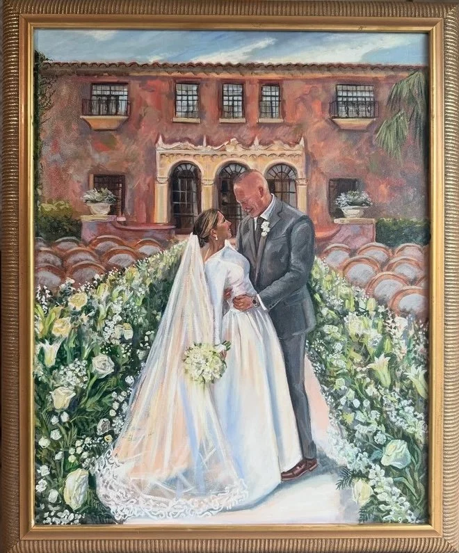 Painting of a bride and groom standing outdoors on their wedding day, surrounded by white flowers, with a large brick building in the background.