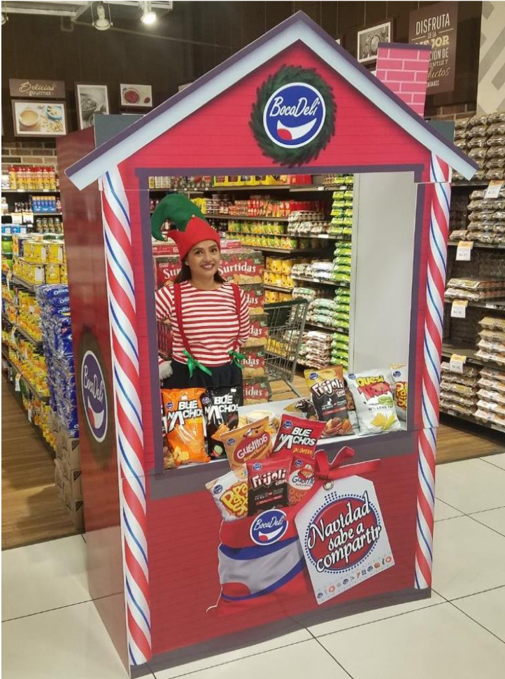 Stand navideño de snacks dentro de un supermercado. El espacio está decorado con borde de bastones de caramelo rojo y blanco,  y varias bolsas de snacks en exhibición. Activación organizada por Marketing Experience. 