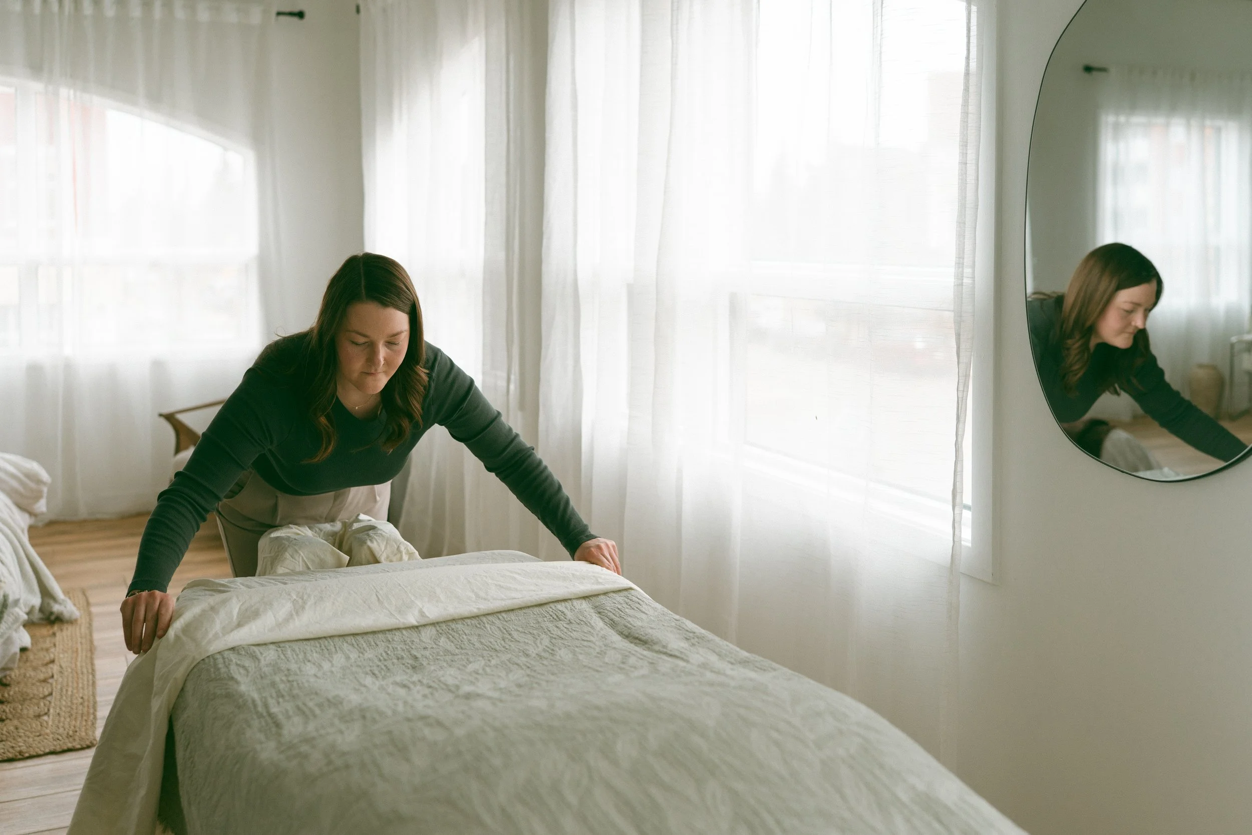 Emma Johannesson - Registered Massage Therapist folding the blankets on her massage bed