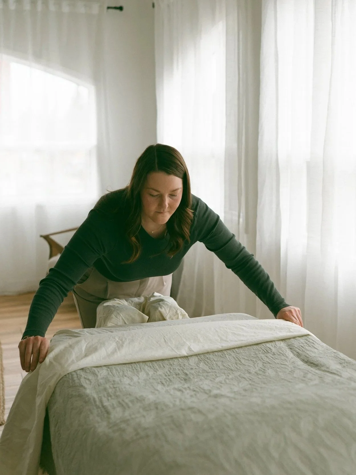 Emma folding blankets on her massage bed