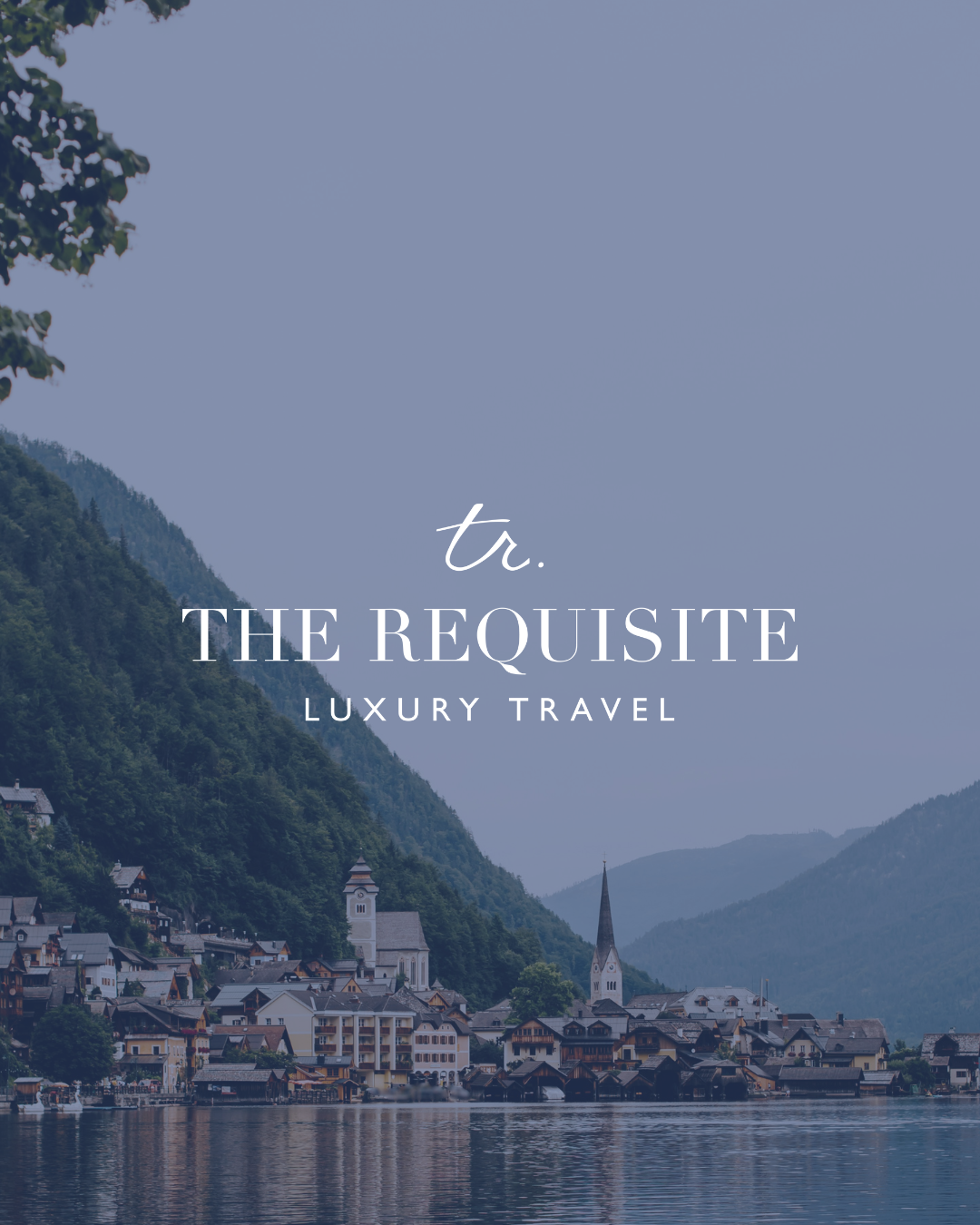 A scenic view of a lakeside town with a church steeple, surrounded by green mountains under a cloudy sky, with overlaid text that says 'tr. THE REQUISITE LUXURY TRAVEL'.